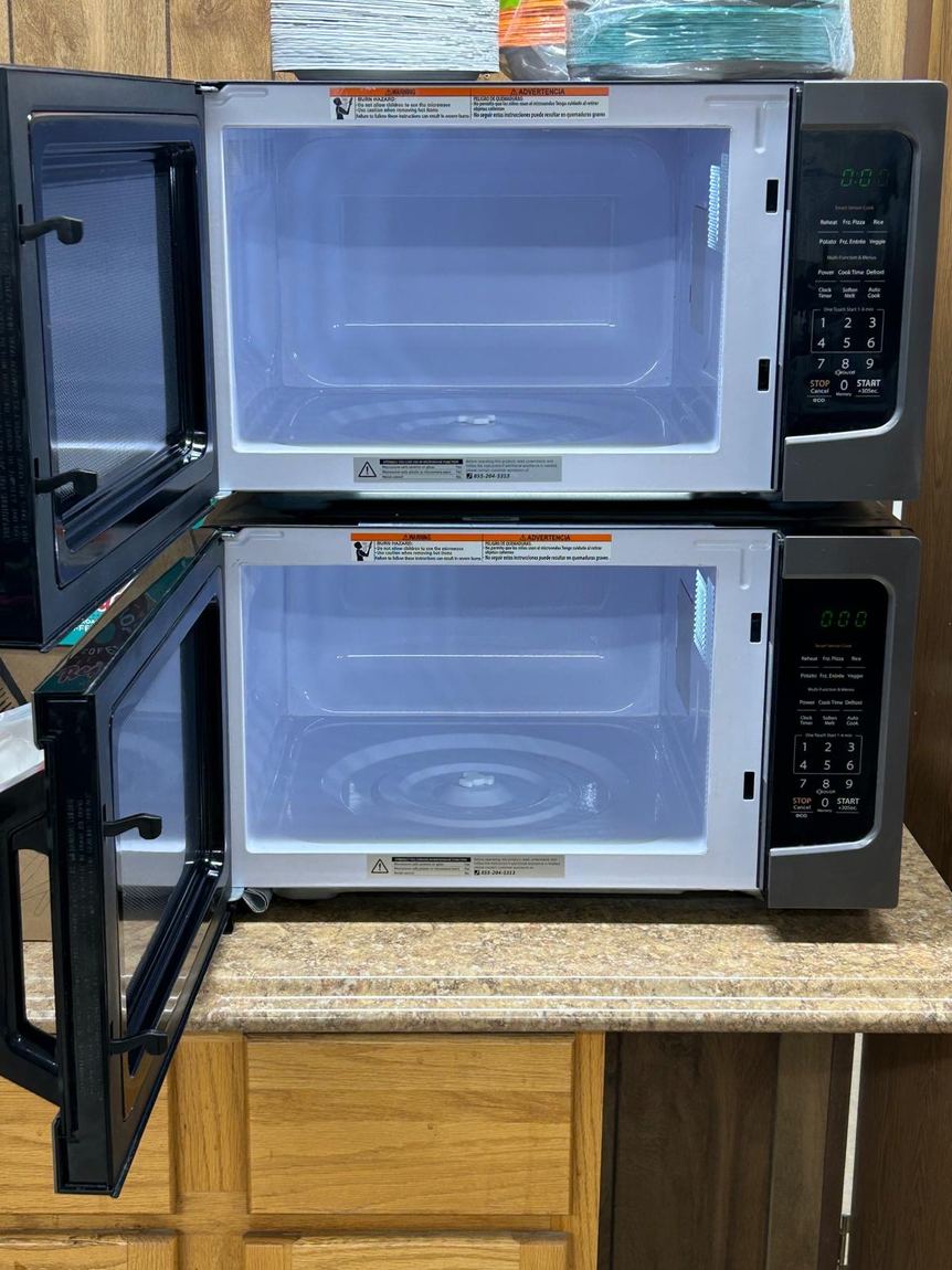 Two microwave interiors cleaned until spotless, doors open