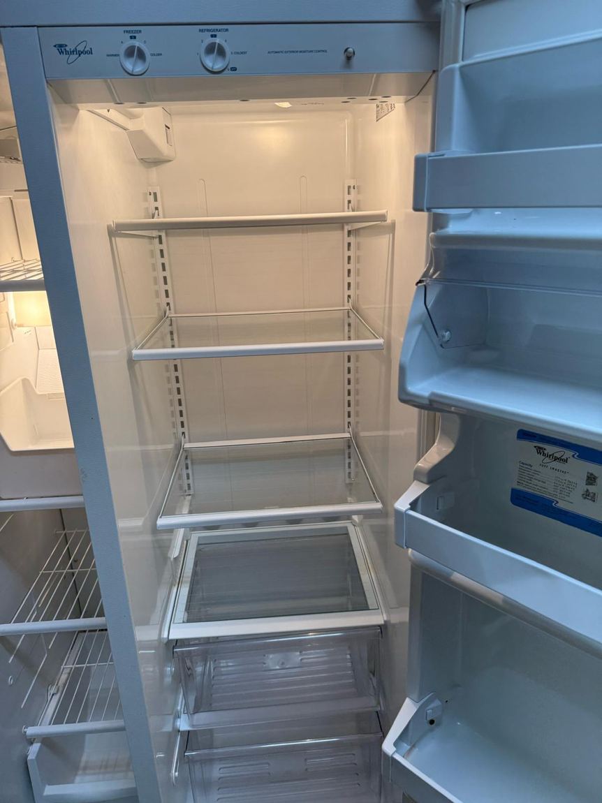 The same refrigerator after cleaning, shelves empty and gleaming