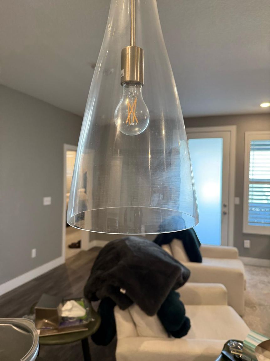 A glass pendant light fixture cleaned until clear